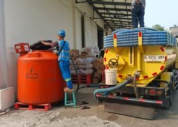 Petugas menyedot limbah cair menggunakan truk tinja ke tangki penampungan di area industri