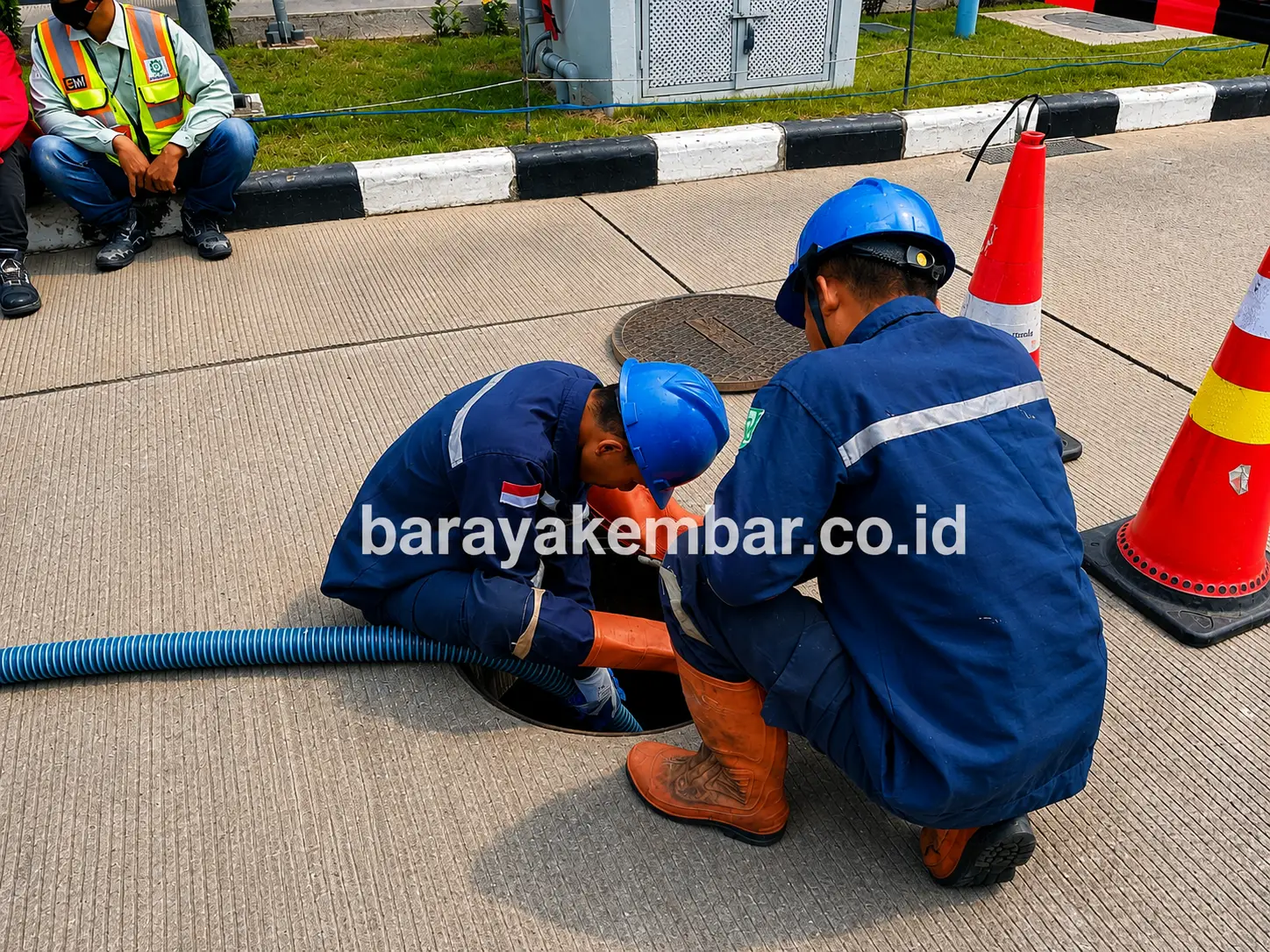 Dua teknisi Jasa Limbah bersiap membuka manhole di fasilitas industri dengan rambu pengaman terpasang